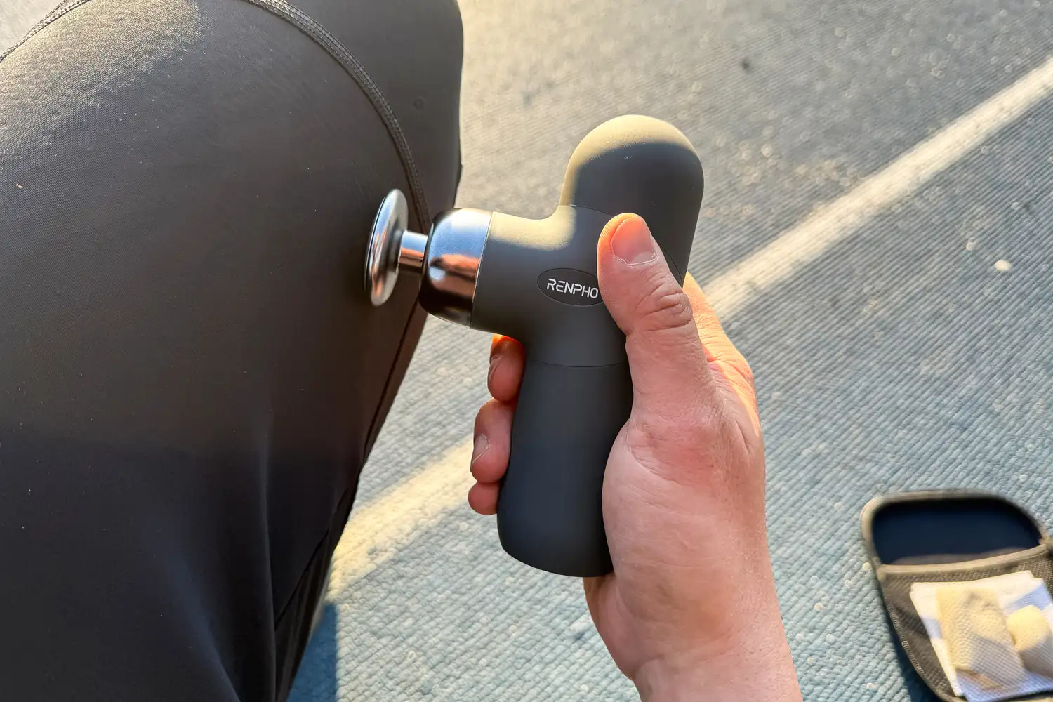 A person uses the Renpho Mini Thermal Massage Gun on their knee
