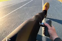 A person uses the Renpho Mini Thermal Massage Gun on their leg