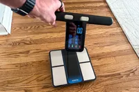 A person holds up the heart rate monitor on the Renpho MorphoScan Smart Body Scale