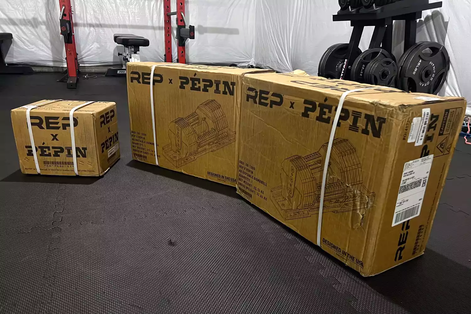 The REP Fitness REP x PÉPIN FAST Series Adjustable Dumbbell in shipping boxes