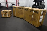 The REP Fitness REP x PÉPIN FAST Series Adjustable Dumbbell in shipping boxes