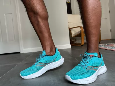 A person wearing the Saucony Men's Kinvara 14 Sneakers