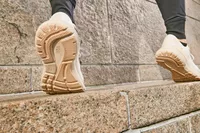 A close up of the sole of the Brooks Adrenaline GTS 23 on feet walking on stone surface