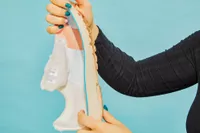 Hands holding half of the Brooks Adrenaline GTS 23 sneaker