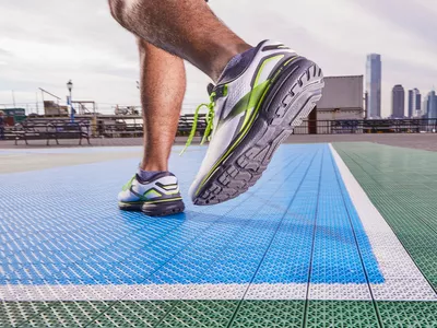 Close-up of a person wearing Brooks Men's Ghost 15 Running Shoes on an outdoor track