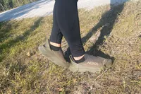 A person's legs posing while wearing Hoka Restore TC Recovery Shoes