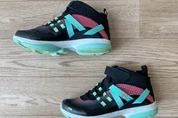 A side view of a pair of Ryka Devotion XT Mid Top Training Shoes on a wooden floor