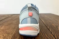 A Ryka Women's Invoke Walking Shoe from the back on a wooden surface