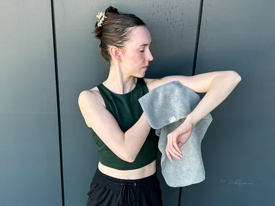 A person wipes their arm using the S&T INC. Microfiber Sweat Gym Towel