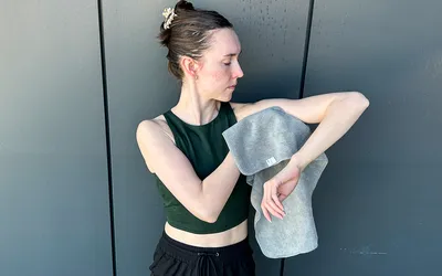 A person wipes their arm using the S&T INC. Microfiber Sweat Gym Towel