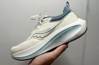 A person holds up the Saucony Men's Surge 3 Everyday Shoe