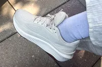 A side view of a person wearing the Saucony Women's Echelon 10 Running Shoe