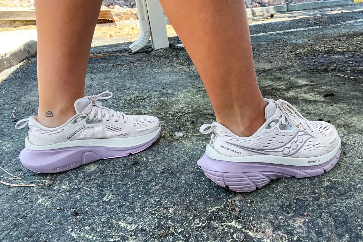 A person walks outside while wearing the Saucony Women's Guide 18 Sneakers