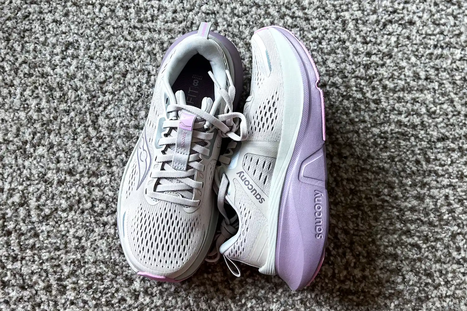 A pair of Saucony Women's Guide 18 Sneakers on carpet