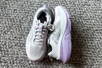 A pair of Saucony Women's Guide 18 Sneakers on carpet