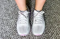 A person wears the Saucony Women's Guide 18 Sneakers on carpet