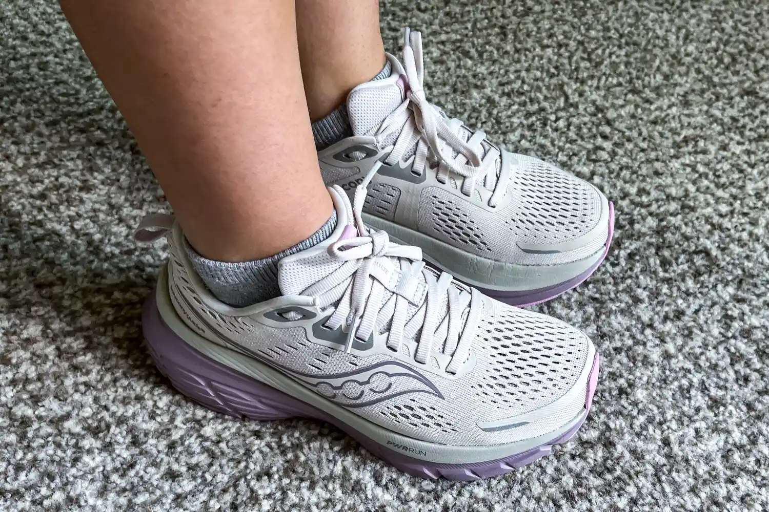 A person wearing the Saucony Women's Guide 18 Sneakers