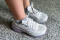 A person wearing the Saucony Women's Guide 18 Sneakers