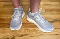 A person wears the Saucony Women's Tide 2 Walking Shoes on a hardwood floor