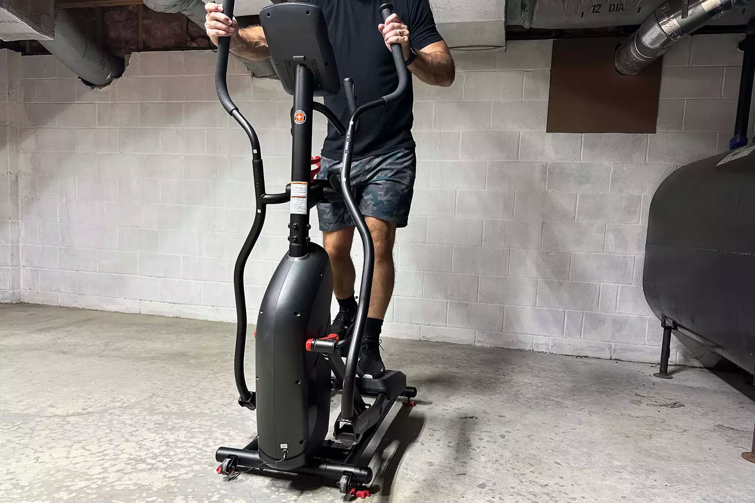 A person exercises on the Schwinn 411 Compact Elliptical Machine