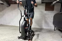 A person exercises on the Schwinn 411 Compact Elliptical Machine