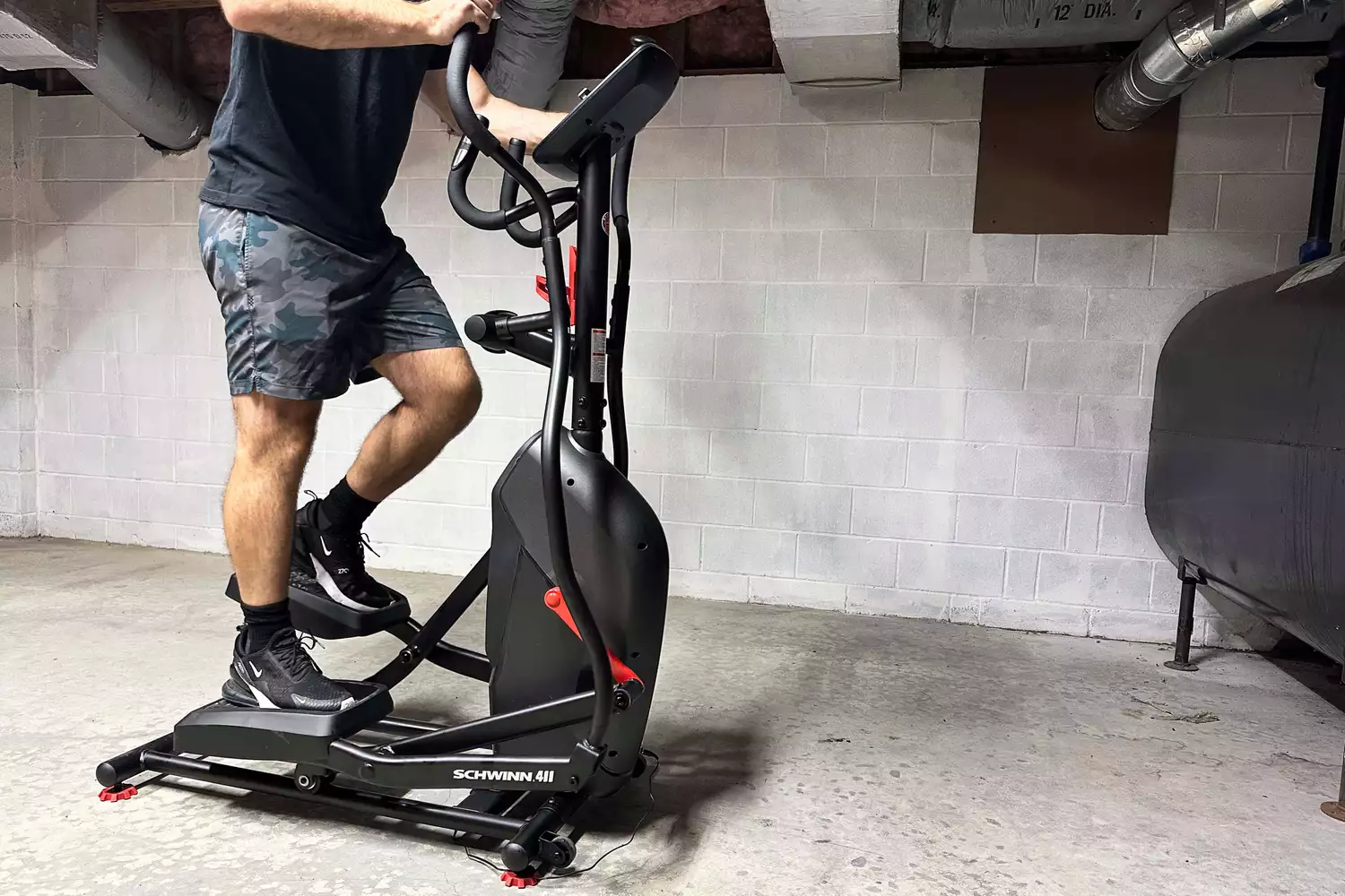 A person exercises on the Schwinn 411 Compact Elliptical Machine