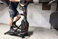 A person exercises on the Schwinn 411 Compact Elliptical Machine
