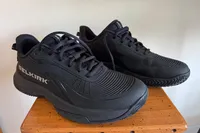 A pair of Selkirk Women's CourtStrike Pro Pickleball Shoes on a small wooden table