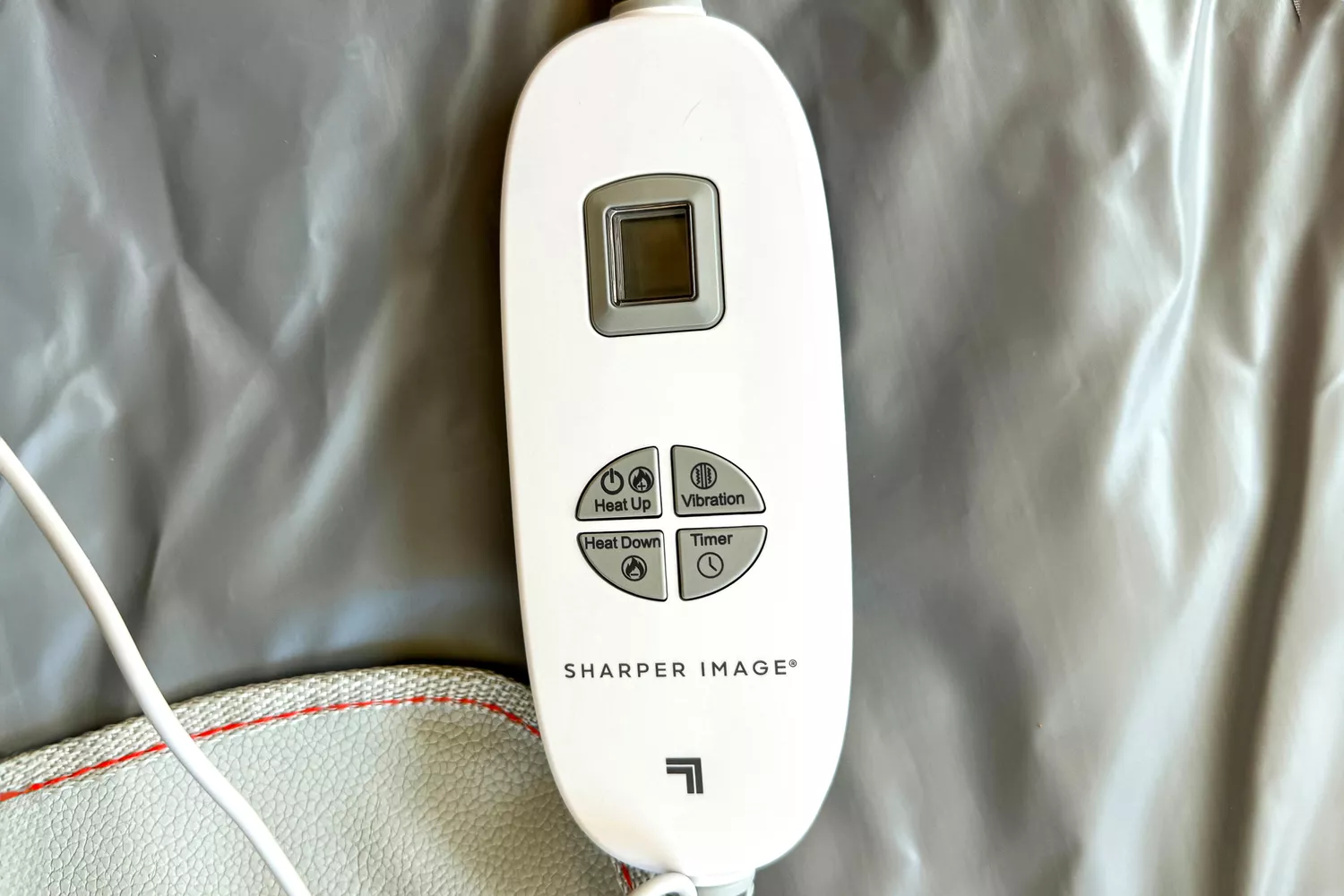 A close-up of the Sharper Image Calming Infrared Heat Sauna Wrap remote
