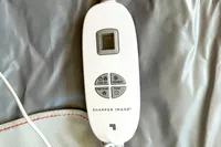 A close-up of the Sharper Image Calming Infrared Heat Sauna Wrap remote