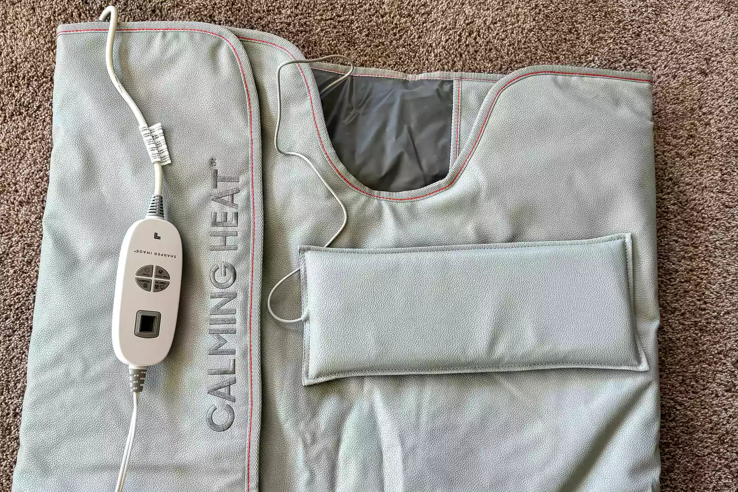 A close-up of the Sharper Image Calming Heat Sauna Infrared Wrap on a carpet
