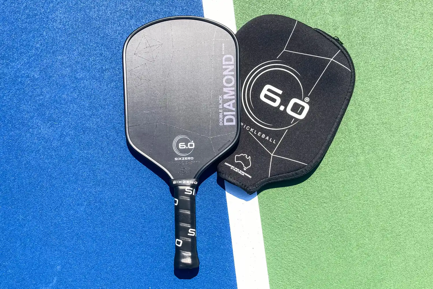 The Six Zero Double Black Diamond Control Pickleball Paddle and cover on a court