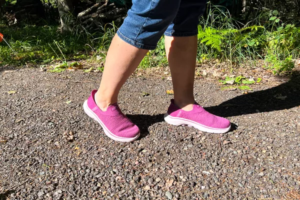 A person walks outside while wearing the Skechers Slip-Ins Go Walk 7 Springtime Walking Shoes