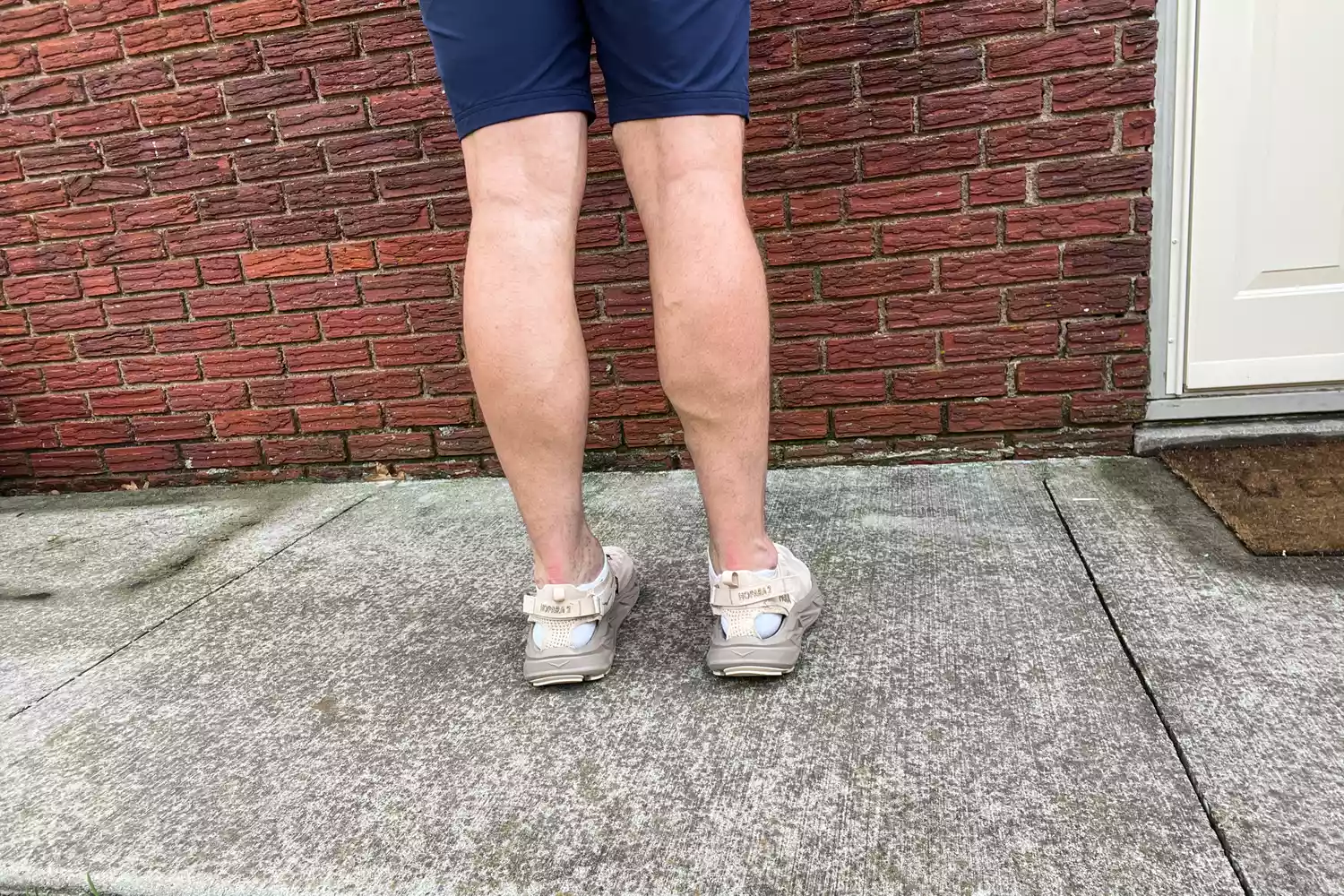 A person wears the Hoka Men's Hopara 2 Sandals outside