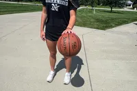 A person dribbles the Spalding Rookie Gear Youth Indoor-Outdoor Basketball