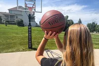 A person shoots the Spalding Rookie Gear Youth Indoor-Outdoor Basketball