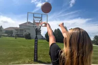 A person shoots the Spalding Rookie Gear Youth Indoor-Outdoor Basketball