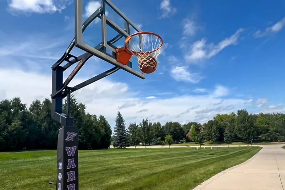 A person shoots the Spalding Rookie Gear Youth Indoor-Outdoor Basketball through a net