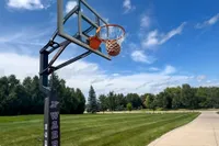 A person shoots the Spalding Rookie Gear Youth Indoor-Outdoor Basketball through a net