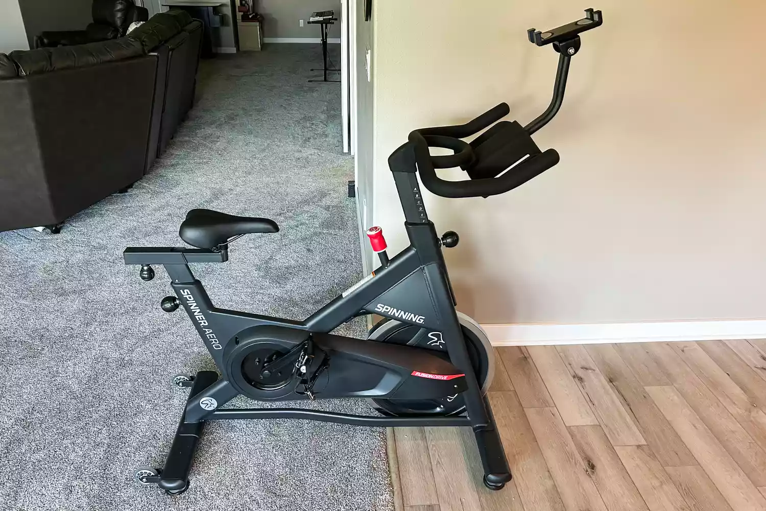 The Spinning Aero Connected Spinner Bike on a wood and carpeted floor