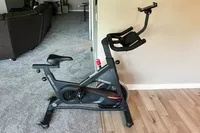 The Spinning Aero Connected Spinner Bike on a wood and carpeted floor