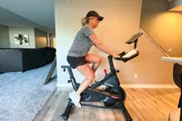 A side view of a person cycling on the Spinning Aero Connected Spinner Bike