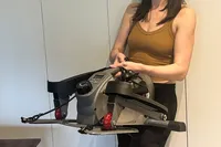 A person lifts the Sunny Health & Fitness Smart Stand/Sit Mini Elliptical Exercise Trainer