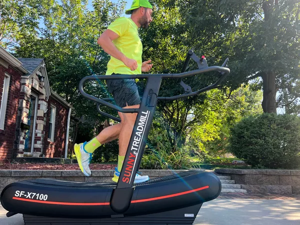 A person runs on the Sunny Health & Fitness SF-X7100 Premium Curve Manual Treadmill