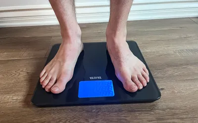 A person stands on the Tanita HD-384 Digital Bathroom Scale