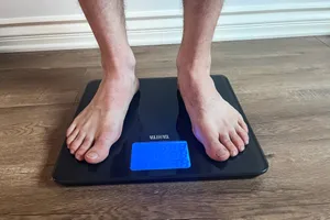 A person stands on the Tanita HD-384 Digital Bathroom Scale