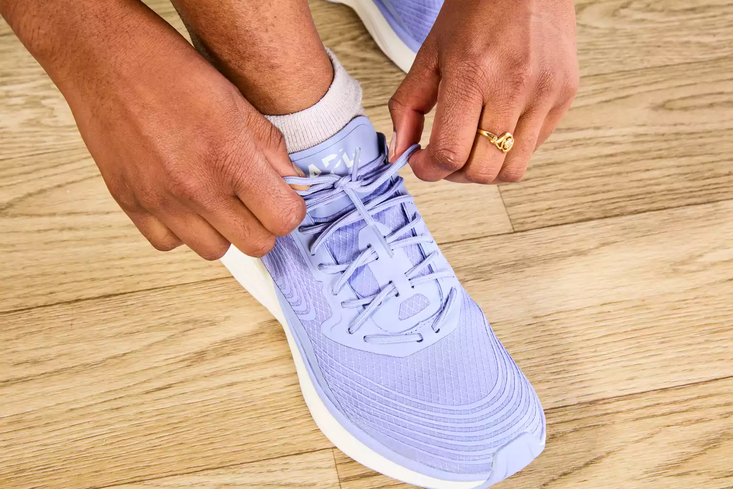 Person tying laces of APL Streamline Running Shoes