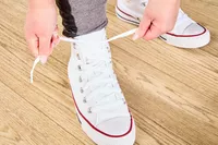 Person tying Converse Chuck Taylor All Star Sneakers