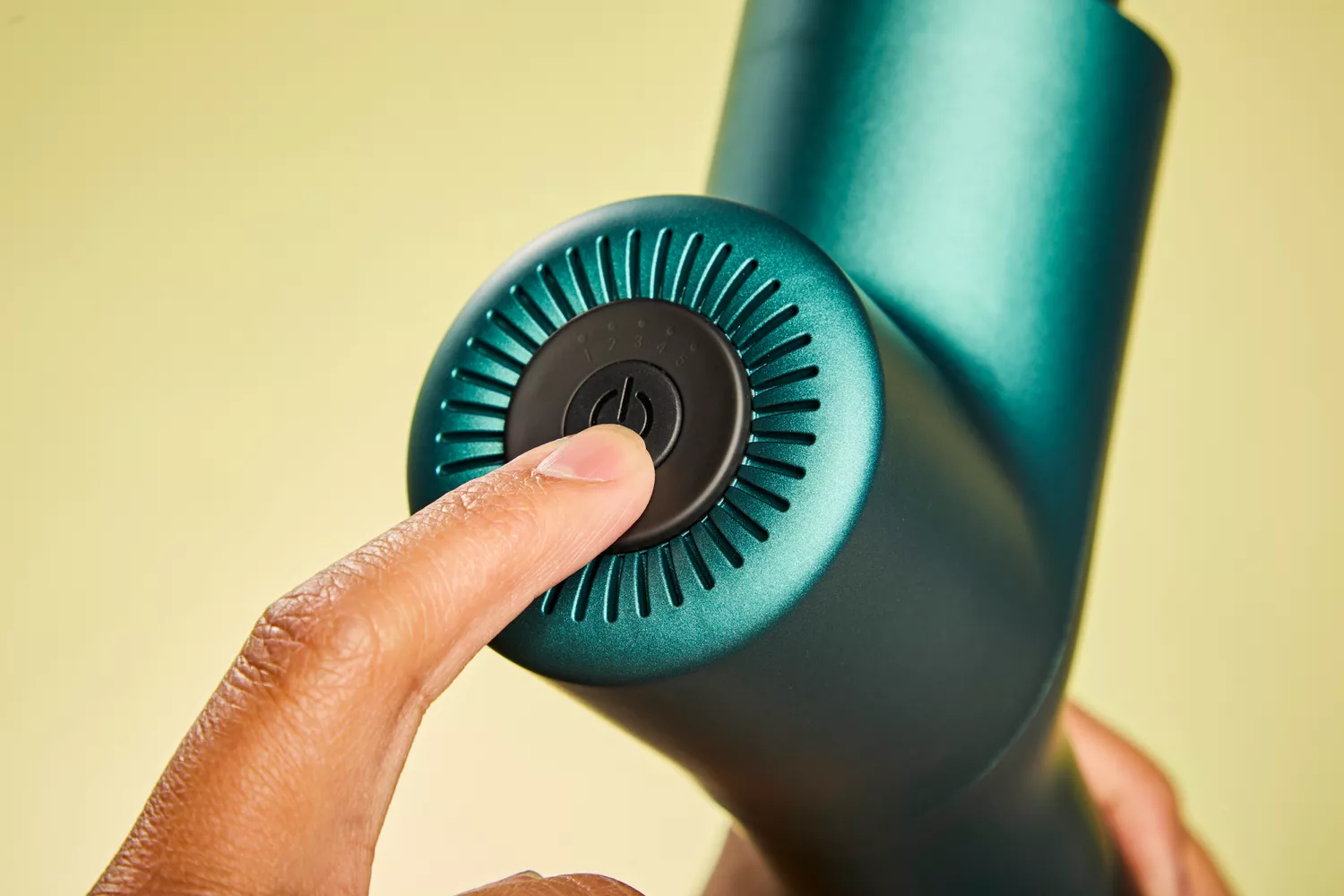 Person pressing button on Ekrin Athletics B37 Percussion Massager