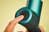 Person pressing button on Ekrin Athletics B37 Percussion Massager